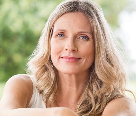 Blonde woman in her 50's smiling at the camera