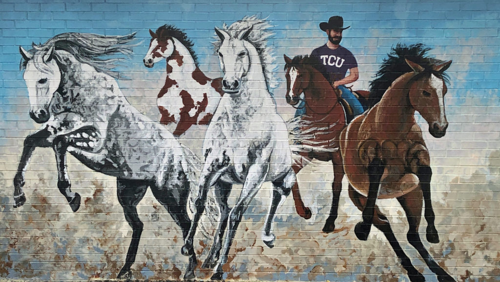 Mural of TCU cowboy with horses in Fort Worth Texas