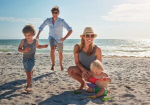 Woman is on the beach with her husband and two kids hoping to feel confident in a bathing suit again.